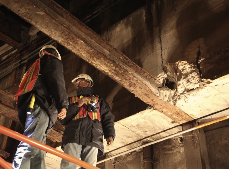 Inspectores revisando una viga estructural de acero en obra